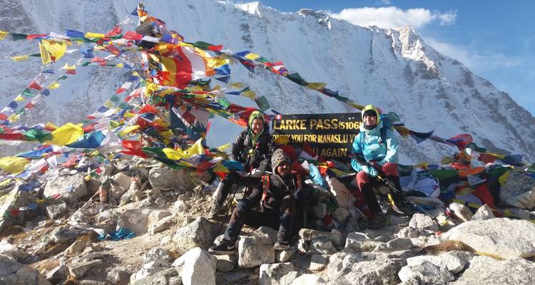 Groep mensen met kleurrijke vlaggen op een bergpas.