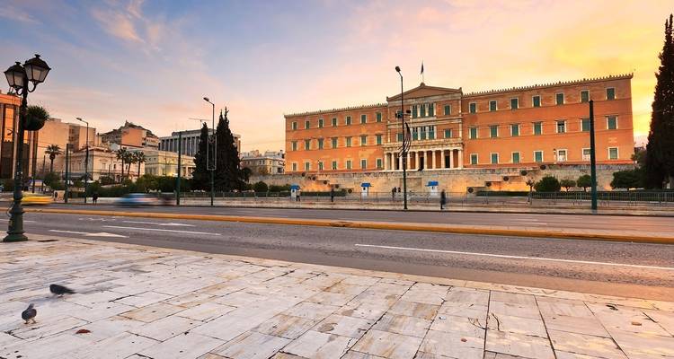 Das Hellenische Parlament bei Sonnenuntergang mit einem leeren Platz davor.