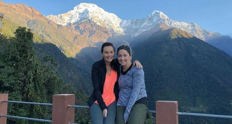 Twee mensen poseren met bergen op de achtergrond.