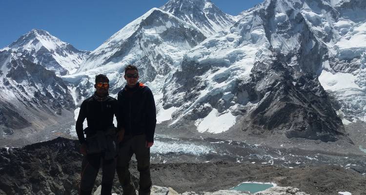 Two people in front of a snowy peak.