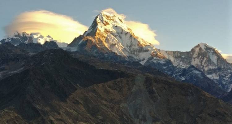Een majestueuze besneeuwde bergtop onder een dramatische hemel.