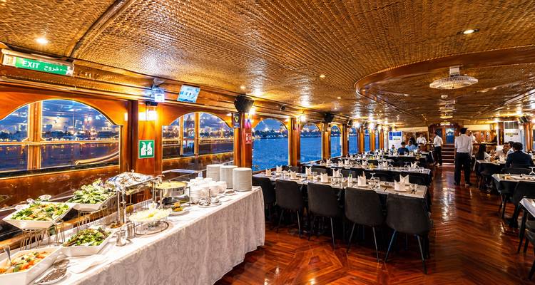 Intérieur élégant d'un navire de croisière-dîner préparé pour un buffet avec de grandes baies vitrées sur le fleuve