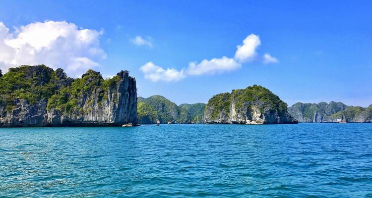 Eaux turquoise et îles calcaires spectaculaires sous le ciel bleu éclatant de la baie d'Halong