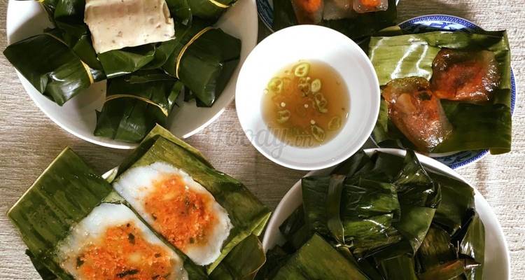 Sortiment von Hue-Reiskuchen in Blättern eingewickelt und Dip-Sauce auf einem Tisch