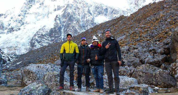 Vier Personen posieren in einem bergigen, felsigen Gebiet.