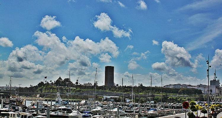 Une marina pleine de bateaux à Rabat avec un paysage urbain en arrière-plan.
