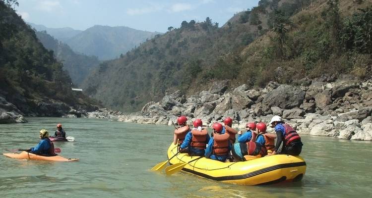 Group of rafters on a calm river with scenic hills.