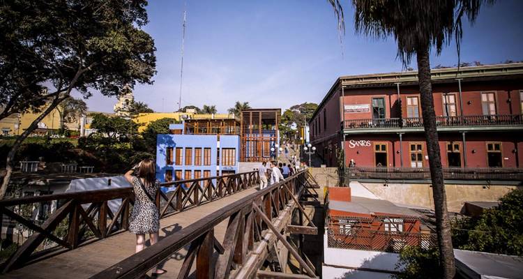 Los peatones cruzan el puente de madera Puente de los Suspiros sobre los coloridos edificios coloniales en el distrito de Barranco de Lima.
