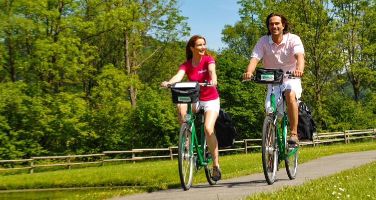 Happy couple cycling on a scenic road.