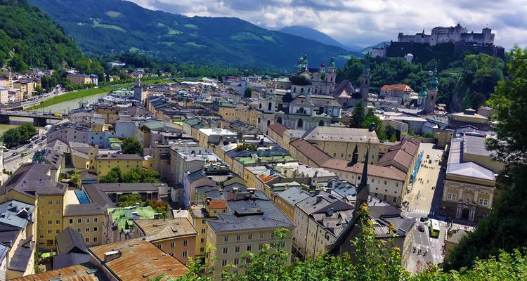 Une vue pittoresque de Salzbourg, Autriche, avec des bâtiments historiques et des collines en arrière-plan.