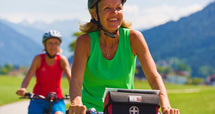 Des cyclistes profitant d'une balade avec des montagnes en arrière-plan.