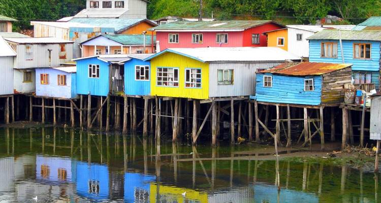 Casas de colores vibrantes sobre pilotes a lo largo de la ribera del río.