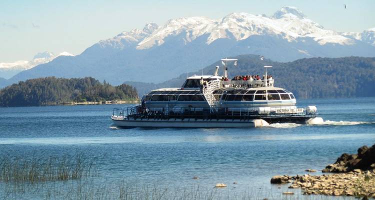 Un ferry navegando por un hermoso lago rodeado de montañas.