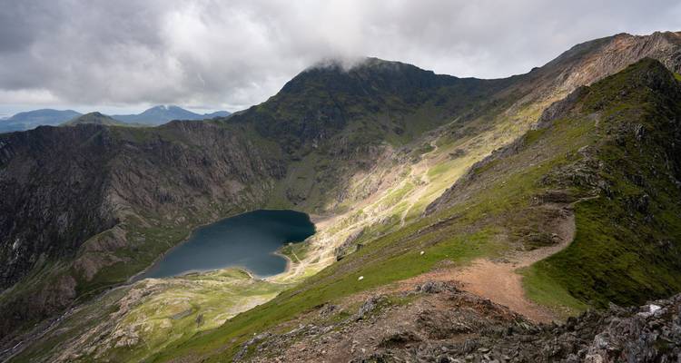 Een meer gelegen in een bergachtig gebied met vlekken zonlicht.