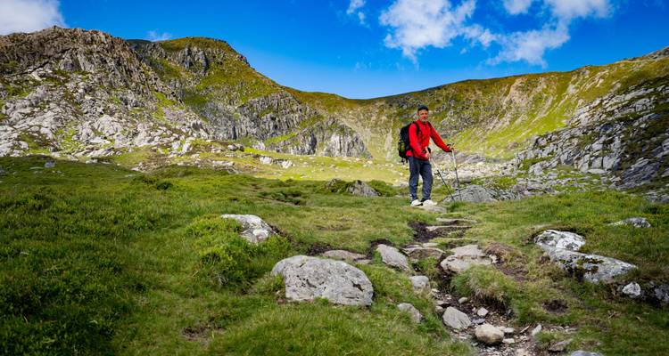 Een man die poseert in een rotsachtig berglandschap.