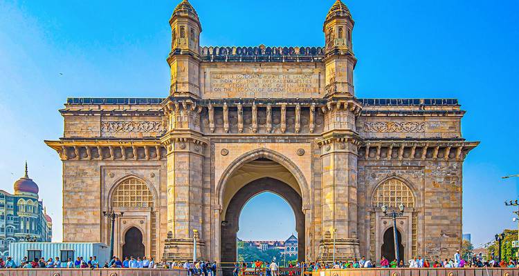 Porte de l'Inde avec une foule sous un ciel dégagé.
