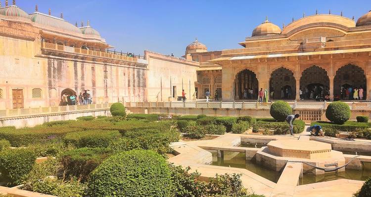 Tuinen op een historische locatie met mensen en gebouwen.