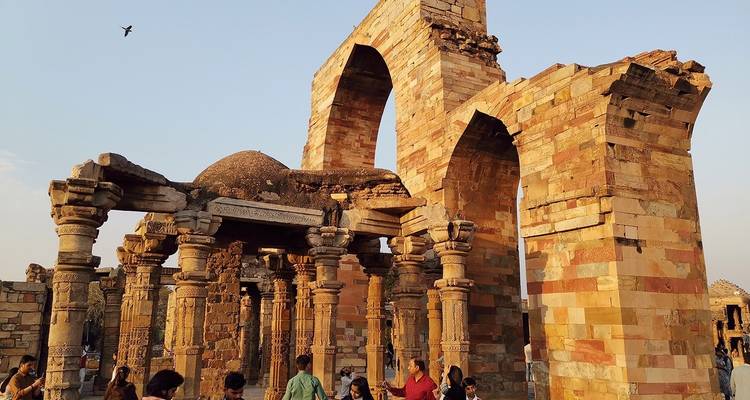 Ruïnes van een oude structuur met toeristen.