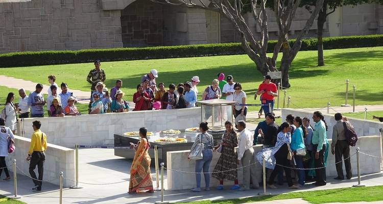 Een groep mensen verzameld rond een omheinde structuur in een tuin.