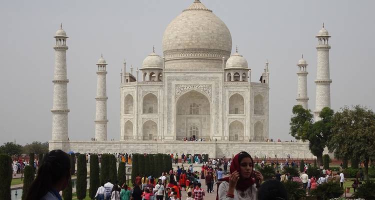 Een zicht op de Taj Mahal met veel bezoekers op de voorgrond.