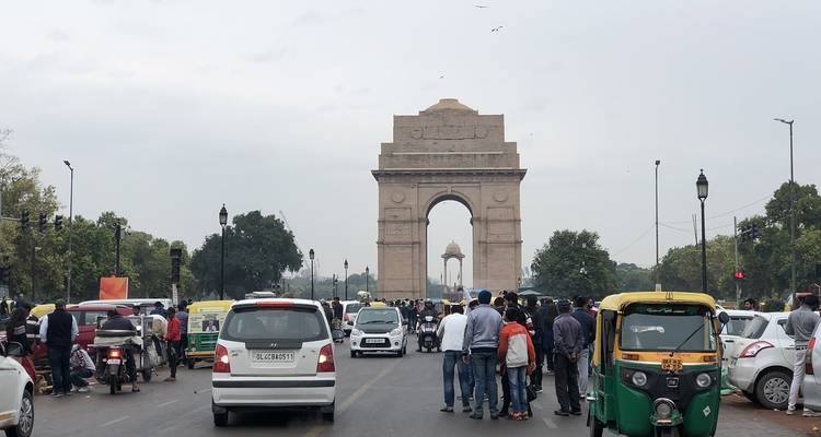 India Gate met verkeer en mensen op de voorgrond.