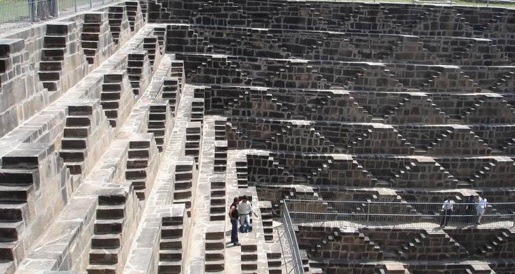 Mensen die door een trapput lopen met geometrische patronen.