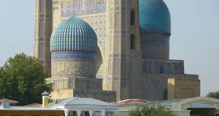 Mezquita ornamentada con cúpulas azules y trabajo detallado de azulejos.