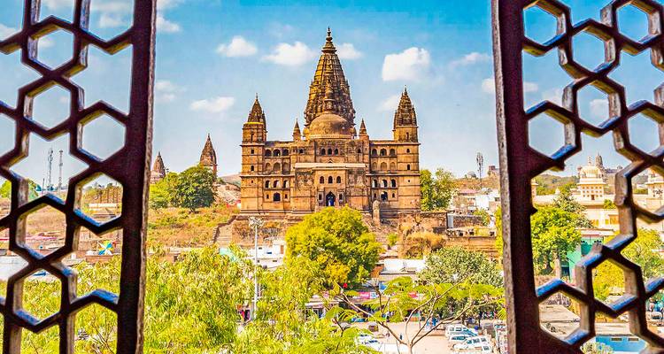 Fuerte de Orchha con torres y diseño intrincado visto desde una ventana.