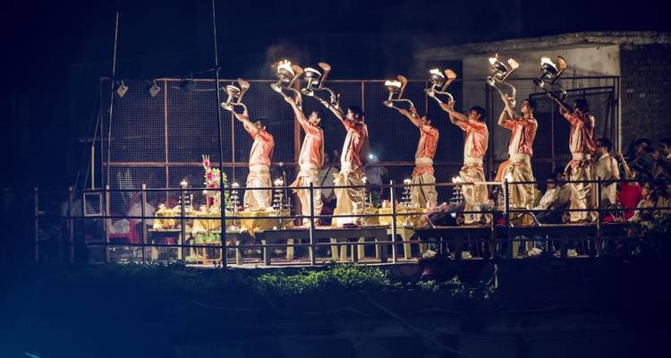 Abendliches Ritual mit mehreren Personen, die zeremonielle Lampen halten.