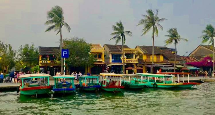 Botes coloridos atracados frente a edificios ribereños animados.