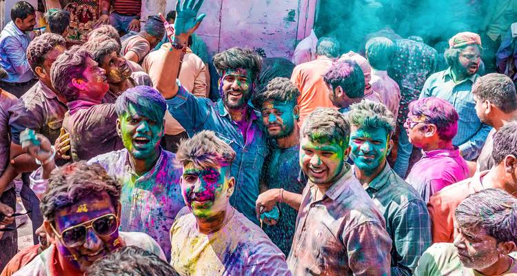 Crowd celebrating Holi festival with vibrant colors.