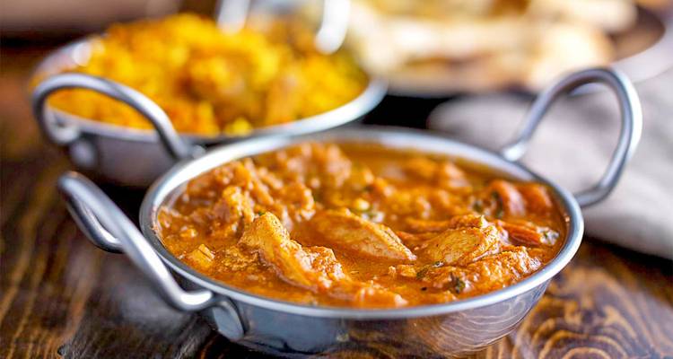 Indian curry served in metal bowls.