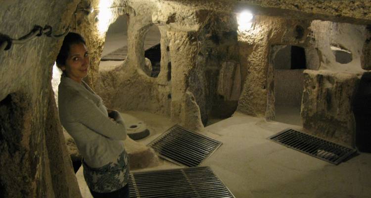 Vrouw in een ondergrondse grot met rotsformaties.