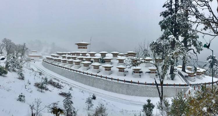 Stupas couverts de neige contre un paysage hivernal.