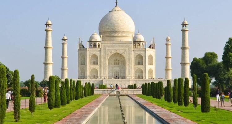 De iconische Taj Mahal met reflecterend bassin en omringende groen.