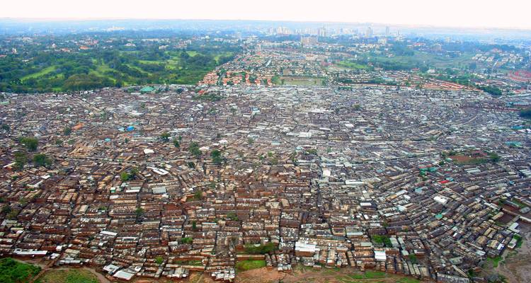 Vue aérienne d'une grande zone urbaine avec des espaces verts et l'horizon de la ville.