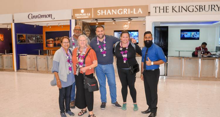 Grupo de personas posando dentro de un edificio con señalización de hotel.