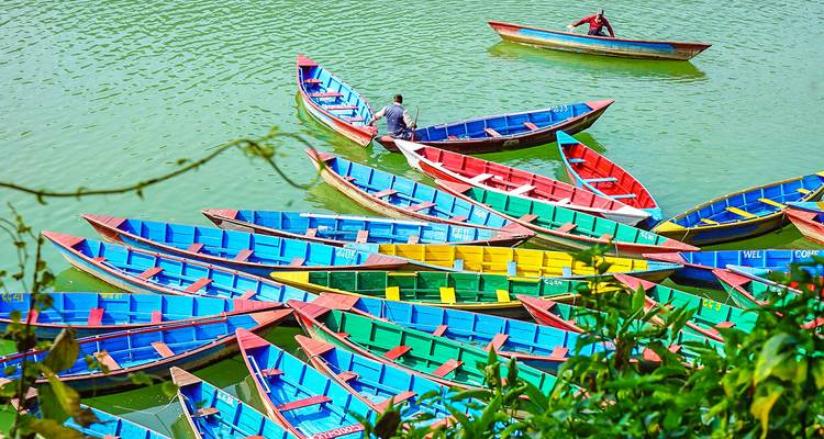 Bateaux colorés flottant sur un lac avec des gens à l'intérieur