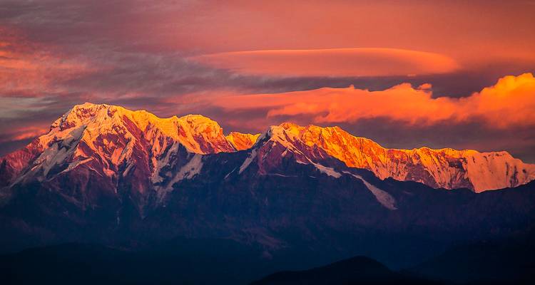 Vue du coucher de soleil sur les montagnes avec un éclairage dramatique et des nuages.