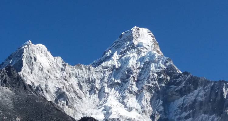 Detaillierter schneegekrönter Berggipfel vor einem klaren Himmel.