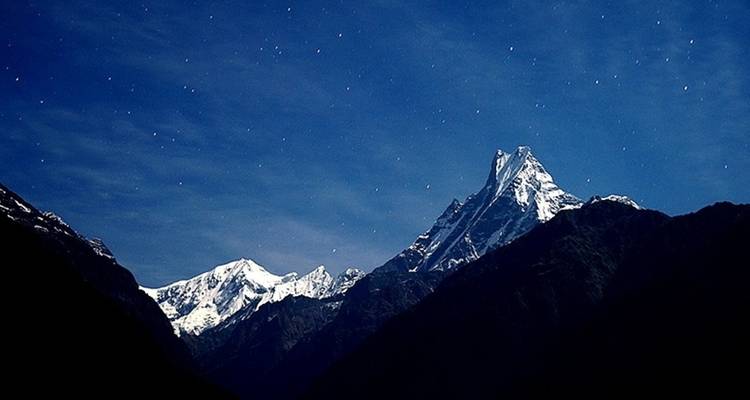 Starry night sky over mountain peak.