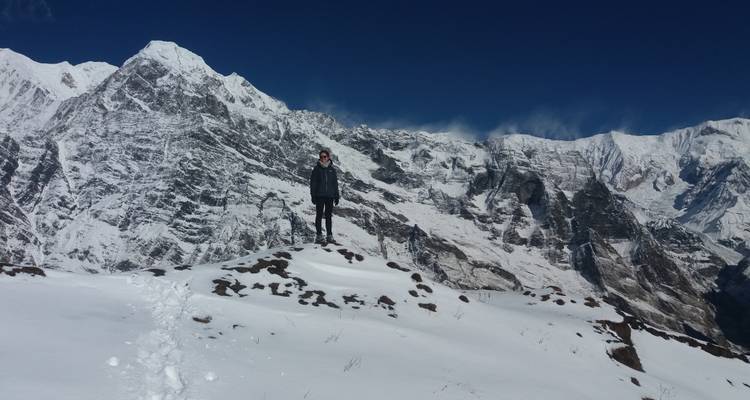 Ein Wanderer, der auf Schnee steht, mit einer Bergkulisse im Hintergrund.