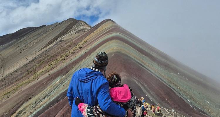 Pareja abrazándose, mirando la Montaña Arcoíris.
