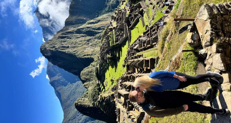 Le couple s'embrasse avec les terrasses emblématiques et le pic du Machu Picchu qui s'élève dramatiquement en arrière-plan.