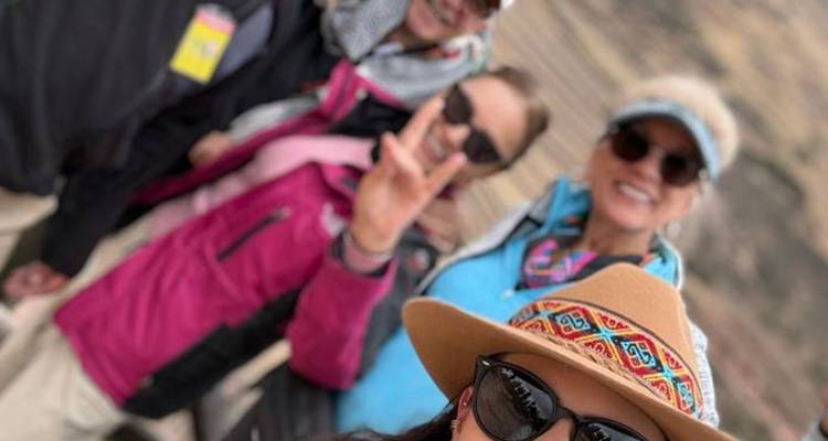 A group of people taking a selfie, one person making a peace sign.