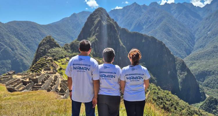 Tres individuos contemplando Machu Picchu.