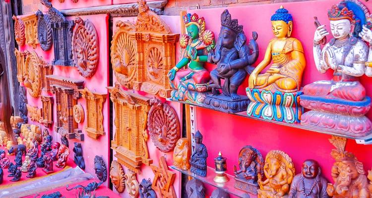 Bunte Skulpturen von hinduistischen Gottheiten an einer Wand.