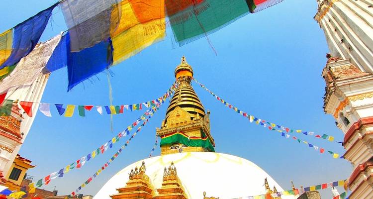 Golden stupa with colorful prayer flags fluttering.