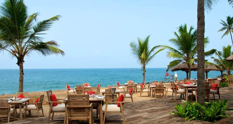 Essbereich im Freien am Strand mit Palmen.