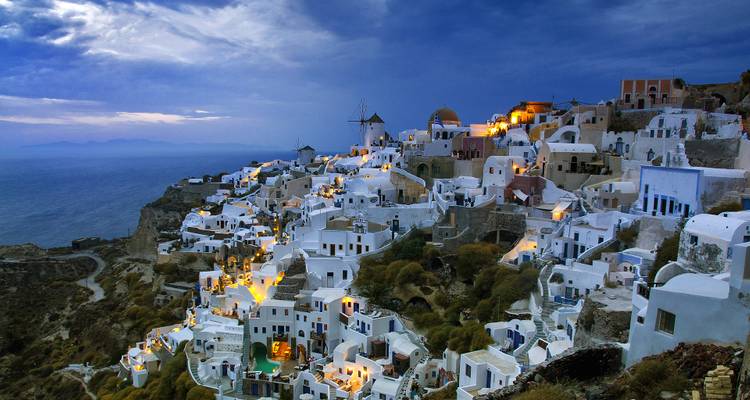 Vue du soir de Santorin avec la ville illuminée face à la mer Égée.